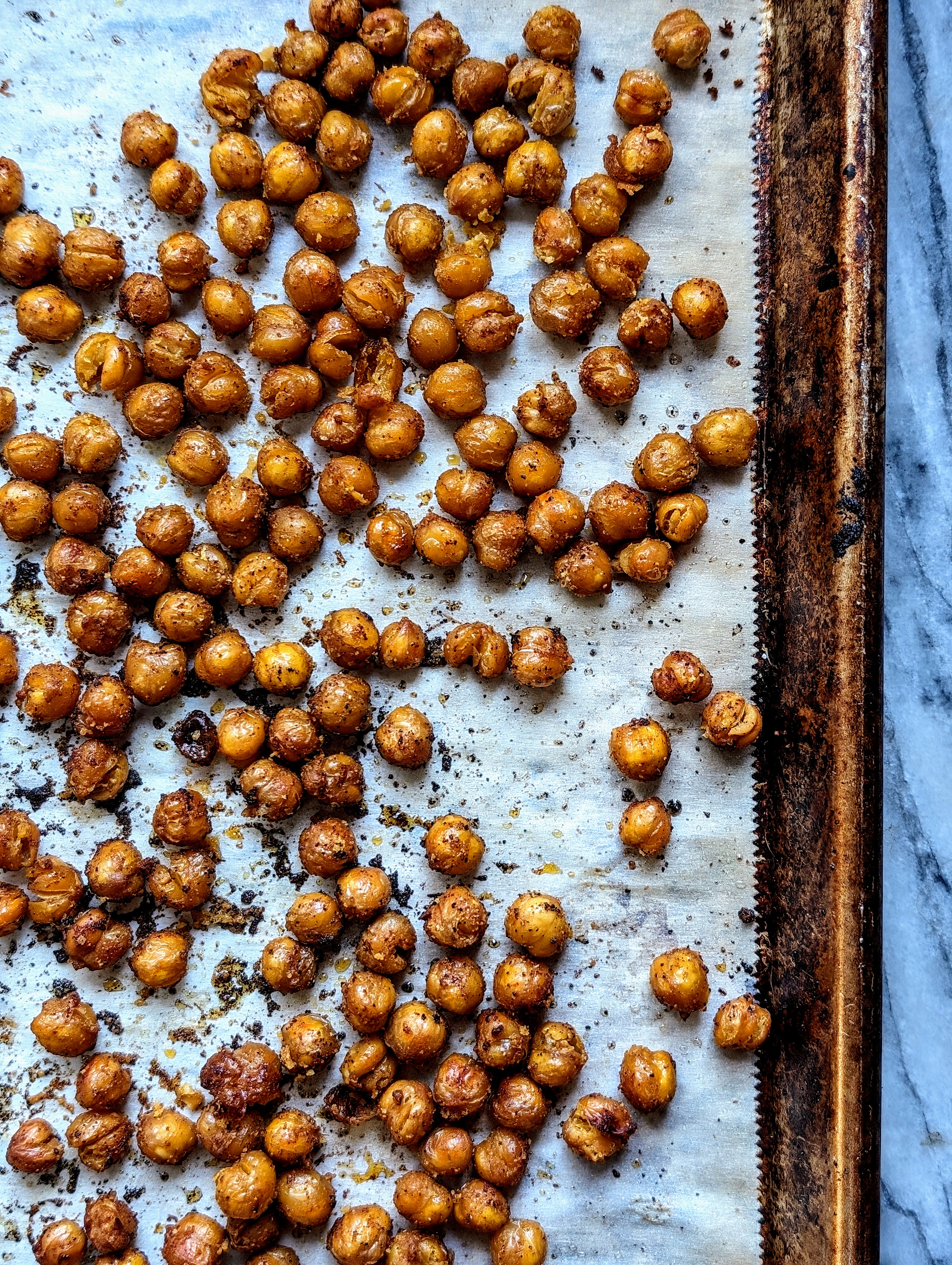 crunchy roasted chickpeas on parchment lined cookie sheet